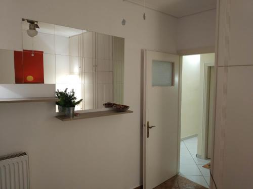 a white kitchen with a mirror and a door at P & G Apartment in Pámfylla