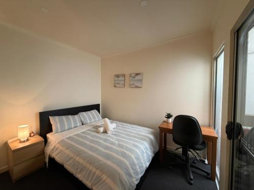 a bedroom with a bed and a desk and a chair at In the heart of Adelaide in Adelaide