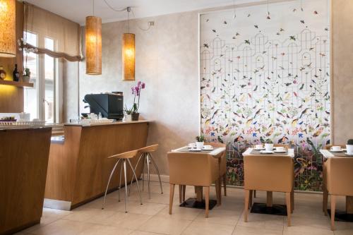 a restaurant with two tables and a wall mural at Hotel Perseo in Florence