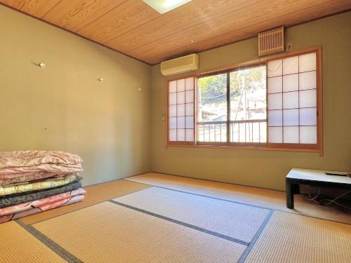 an empty room with a bed and a window at 神庭武道館 in Chichibu