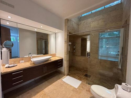 a bathroom with a sink and a shower with a mirror at Casa Aurora Luxury Hotel in Cali