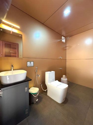 a bathroom with a toilet and a sink at Hayashi Resort in Meppādi