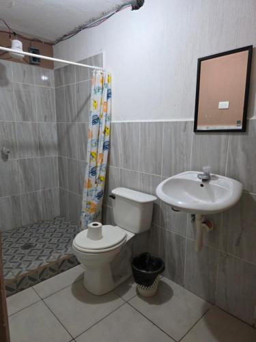 a bathroom with a toilet and a sink at Hotel Fontana Real in Quetzaltenango