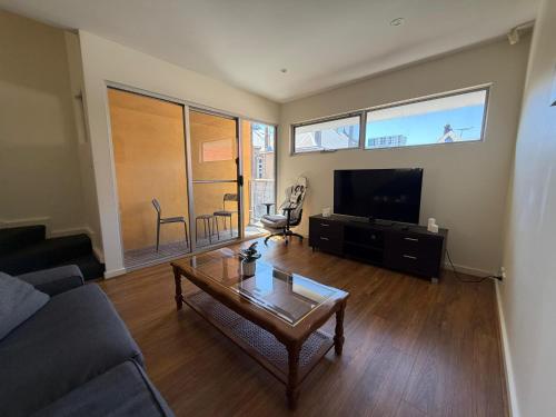 a living room with a couch and a coffee table at In the heart of Adelaide in Adelaide