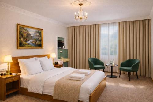 ein Hotelzimmer mit einem Bett und einem Kronleuchter in der Unterkunft Hotel Café Post in Rüdesheim am Rhein