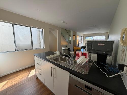 a kitchen with a sink and a tv on a counter at In the heart of Adelaide in Adelaide