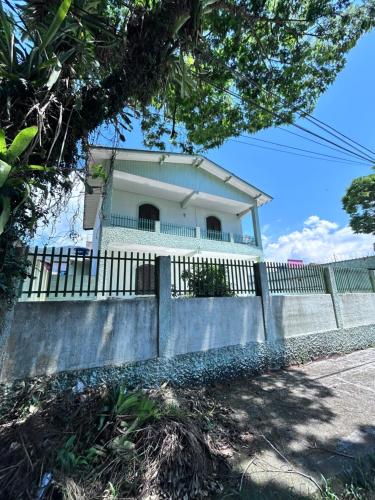 a house with a fence in front of it at Casa espaçosa 100m da praia in Ubatuba
