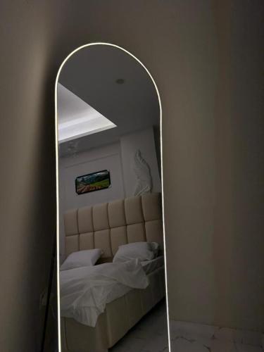 a mirror in a bedroom with a bed in it at Elite Corners Luxury 2BR Apartment The Gate Mall Faisal Town in Barkat