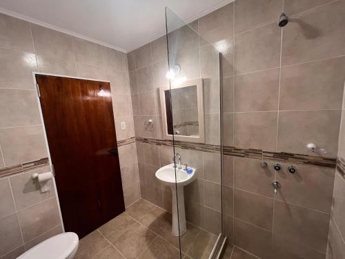 a bathroom with a toilet and a sink and a shower at Costumbres Argentinas Triples En suite in Avellaneda