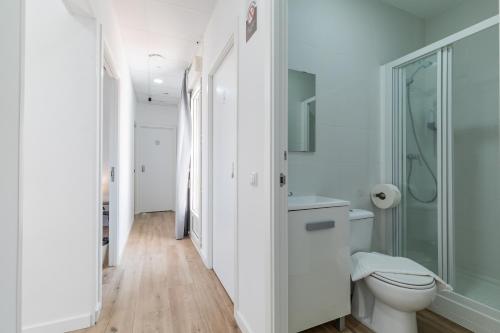 a white bathroom with a toilet and a shower at AYZ Joaquín Pol - Auto check-in property in Madrid