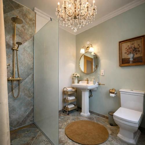 ein Badezimmer mit Waschbecken und Dusche mit Kronleuchter in der Unterkunft Hotel Café Post in Rüdesheim am Rhein