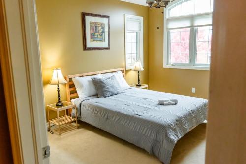 ein Schlafzimmer mit einem Bett, zwei Lampen und einem Fenster in der Unterkunft The Bards Roost - 3BR King Ensuite Family Friendly in Stratford