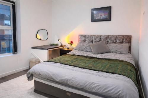 a bedroom with a bed and a desk and a window at Manchester City Cosy Stay - Fresh New Master bedroom Sleeps 3 Guests - 3 Adults in Manchester
