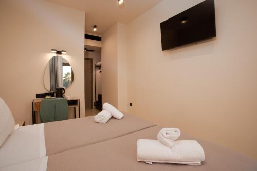 a bedroom with two beds with towels and a mirror at Akti Vigla Premium in Mytilene