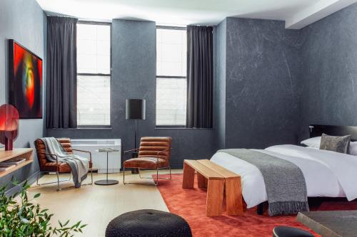 a bedroom with a bed and a table and chairs at Mint House 70 Pine by Kasa in New York