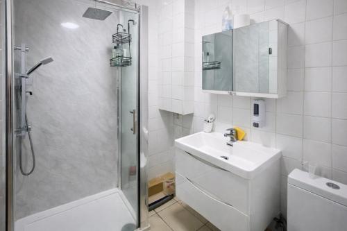 a white bathroom with a sink and a shower at Manchester City Cosy Stay - Fresh New Master bedroom Sleeps 3 Guests - 3 Adults in Manchester