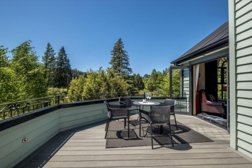 a patio with a table and chairs on a deck at Fontainebleau Luxury B&B in Hanmer Springs