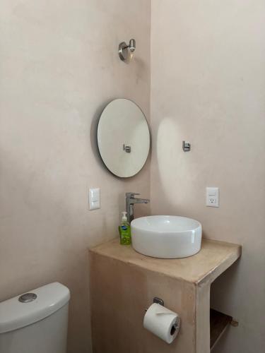 a bathroom with a sink and a mirror and a toilet at Habitat in Barra de Navidad