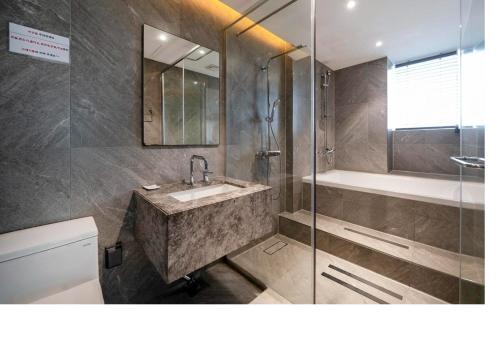 a bathroom with a sink and a shower and a tub at Queentown hotel in Goyang
