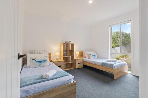a bedroom with two beds and a window at Pelican Lake Holiday House in Merimbula