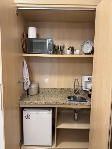 a small kitchen with a sink and a microwave at Flat Mont Blanc Premium in Ribeirão Preto