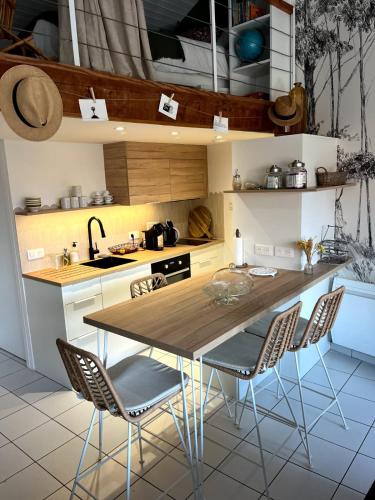 a kitchen with a wooden table and chairs at Le Citrus - Séjour cosy en plein centre historique in Montaigu-Vendée