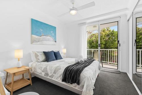 a bedroom with a bed and a large window at Unit 2 Point Break in Yaroomba