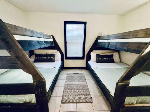 two bunk beds in a room with a window at Urban Aquarium Home for 8 in Galveston