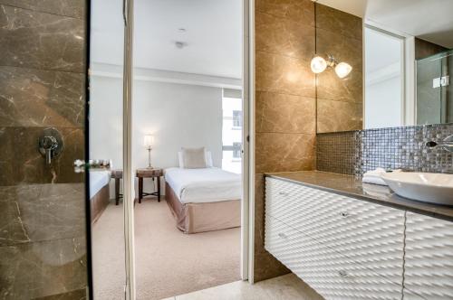 a bathroom with a sink and a mirror at Sea Pearl A1 Beach Resort in Mooloolaba