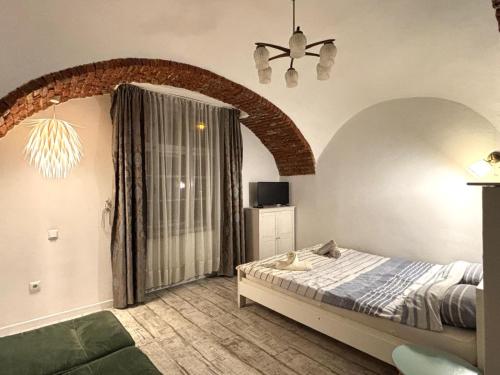 a bedroom with a bed and a large window at Roxen Central Studio Sibiu in Sibiu