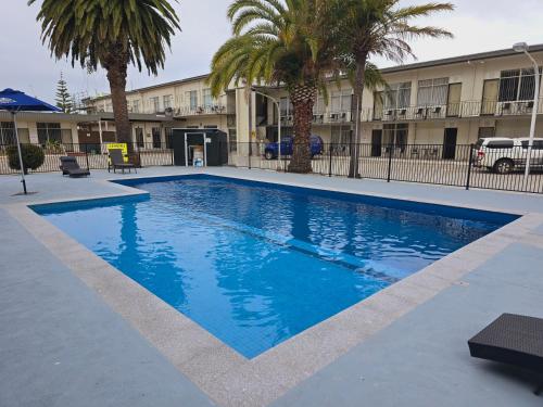 a large blue swimming pool in front of a building at Lakes Entrance RSL Glenara Motel in Lakes Entrance