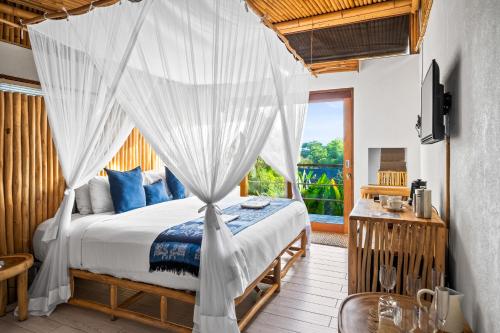 a bedroom with a bed with a mosquito net at Jellyfish Villas Bingin, Uluwatu in Uluwatu