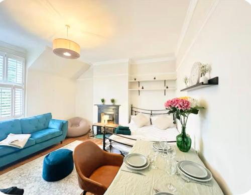 a living room with a table and a couch at Wimbledon Area Apartment in Raynes Park