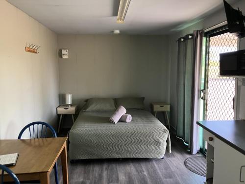 a bedroom with a bed with a pink pillow on it at Major Mitchell Caravan Park in Mitchell