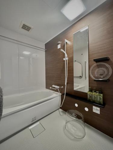 a bathroom with a bath tub and a sink at 愛犬と泊まれる宿 ほこほこsaza 一棟貸し 海も川も徒歩圏内 dog run付き 釣りの穴場 サーフィン 自然 満点星空 蛍鑑賞 最大7名 in Miyazaki