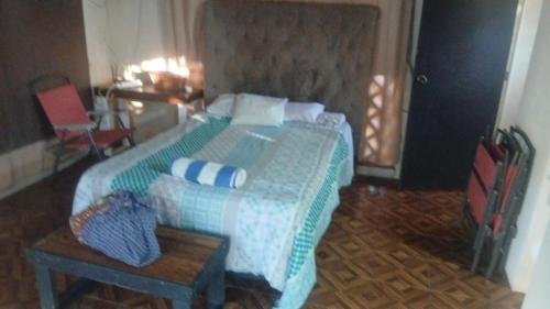 a bedroom with a large bed with a green comforter at Cabañas Puertas del Sol in Telchac