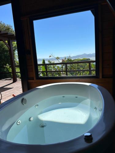 a bath tub in a room with a window at Morada Sunset in Imaruí