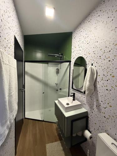 a bathroom with a shower and a sink and a mirror at Apartamento COMPLETO- Próximo ao shopping JL in Cascavel