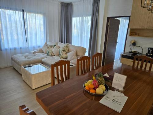a living room with a couch and a table with a bowl of fruit at Vanesa Serenity Villa 1 in Ban Chong Phli