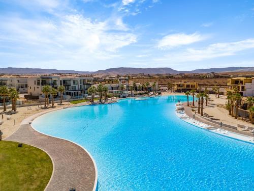 a swimming pool in a resort with palm trees and buildings at Terra Rossa townhouse in St. George