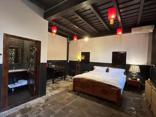 a bedroom with a bed and a bathroom with a sink at Pingyao Yide Hotel in Pingyao