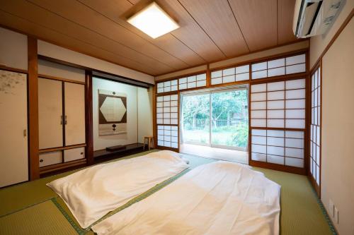 a bedroom with a large bed and a window at villa itsutsu in Kamigotō