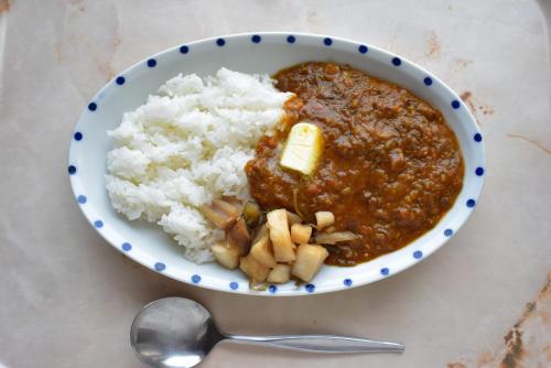a bowl of chili and rice with a spoon at Guest House Moshiripa in Wakkanai