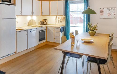 a kitchen with a wooden table and a dining room at Cozy Home In Gråsten With Kitchen in Gråsten