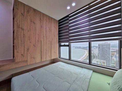 a bedroom with a bed and a window with a view at Little House Sea in Nha Trang