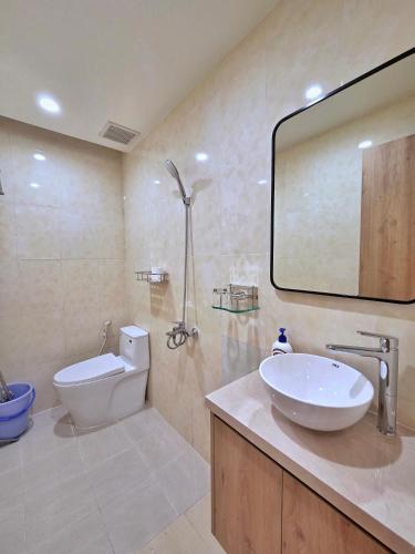 a bathroom with a sink and a toilet and a mirror at Little House Sea in Nha Trang
