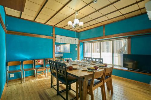 a dining room with blue walls and a table and chairs at 富士山金魚 Fujisan Kingyo in Fujikawaguchiko