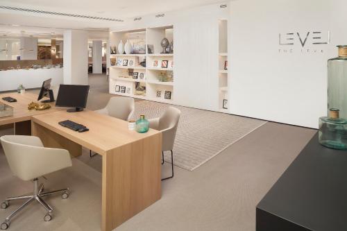an office with a desk with a computer and chairs at Melia Lebreros in Seville