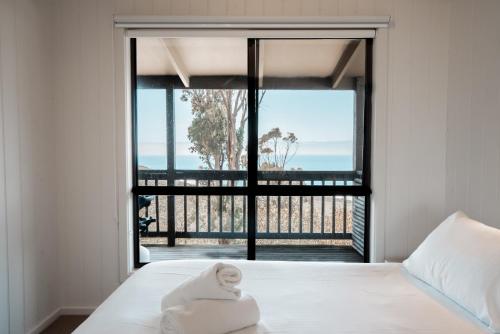 a bedroom with a bed and a large window at Beacon Point Ocean View Villas in Apollo Bay