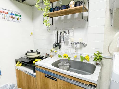 a kitchen with a sink and flowers on the counter at Belmont 301 3min to Station Easy Access Ueno Asakusa Skytree Sleeps 5 in Tokyo